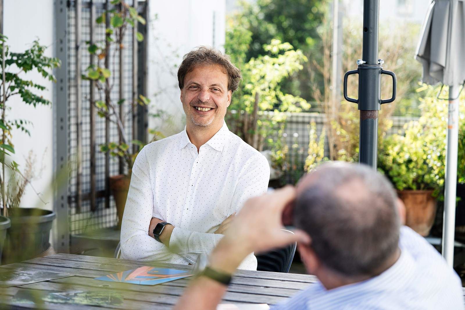 zwei ComTeam Berater auf einer begrünten Terrasse im Gespräch