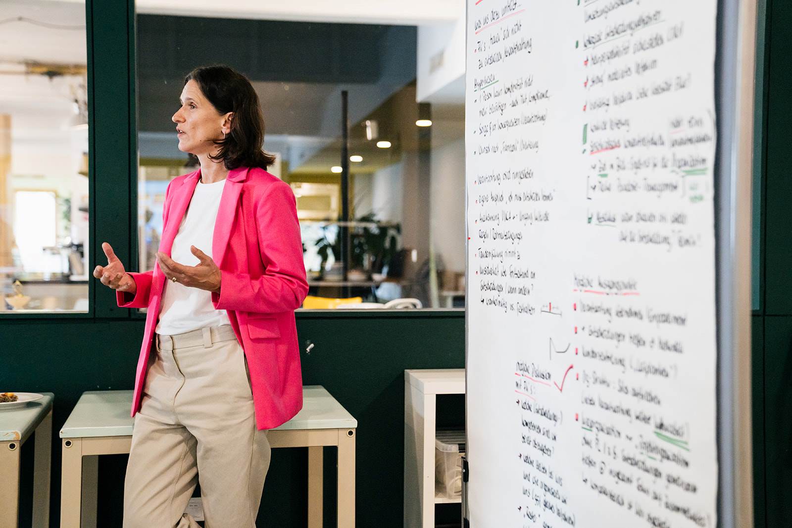 ComTeam Beraterin Elke Adamer steht neben einer Flipchart und erklärt etwas